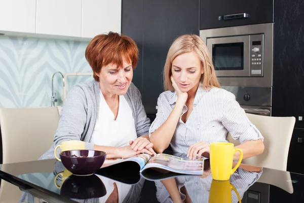 Moeder en dochter lees tijdschrift thuis — Stockfoto