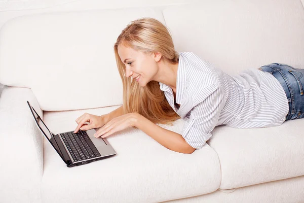 Femme sur le canapé avec ordinateur portable — Photo