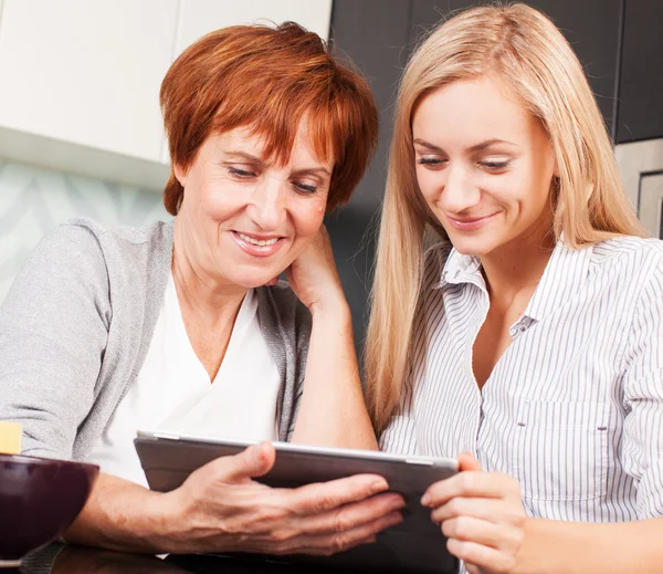 Mother and daughter looking in tablet pc — Stock Photo, Image