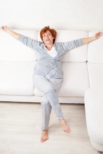 Счастливая зрелая женщина на диване — стоковое фото