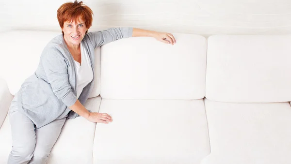 Glad mogen kvinna på soffa — Stockfoto