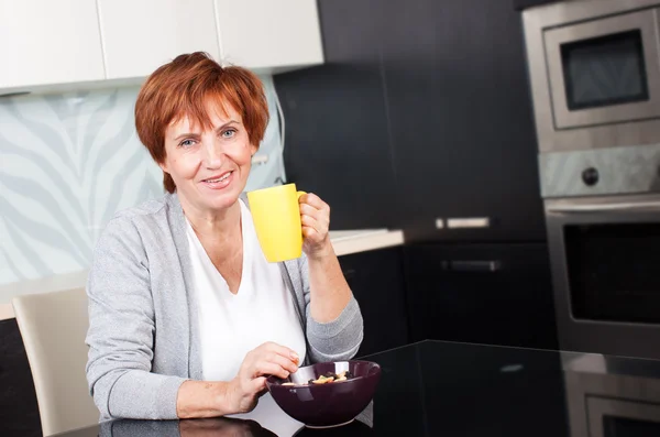 Gelukkig volwassen vrouw op keuken — Stockfoto