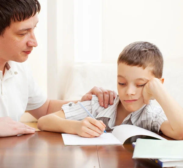 Отец помогает сыну делать уроки — стоковое фото