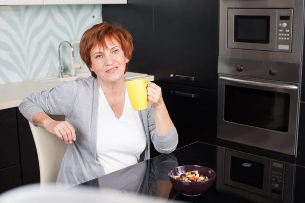 Gelukkig volwassen vrouw op keuken — Stockfoto