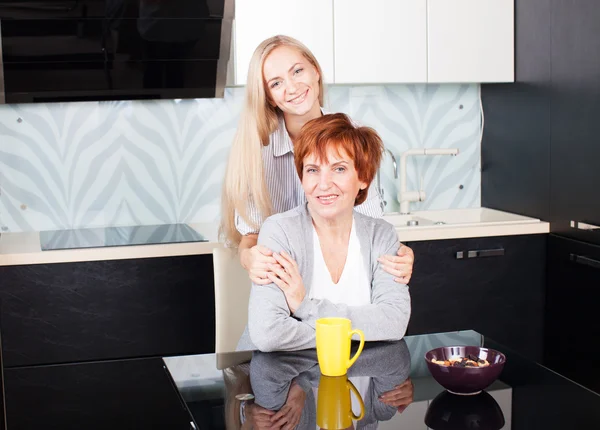Kvinna med dotter på kök — Stockfoto