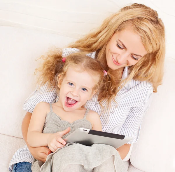 Mãe e filha wiht tablet no sofá — Fotografia de Stock
