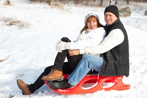 Mature couple sledding — Stock Photo, Image