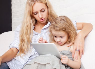 Anne ve kızı kanepe, tablet ile