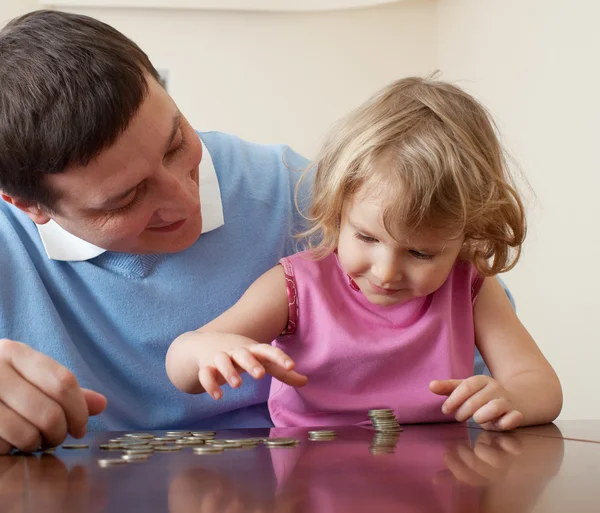 Otec a dcera klade mince — Stock fotografie
