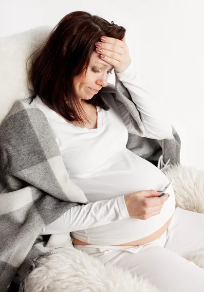 Zwangere vrouw met een thermometer — Stockfoto