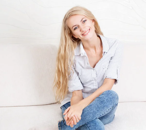 Happy young woman on sofa — Stock Photo, Image