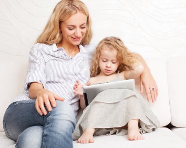 Anne ve kızı kanepe, tablet ile