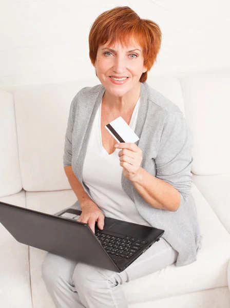 Mogen kvinna med kreditkort och laptop — Stockfoto