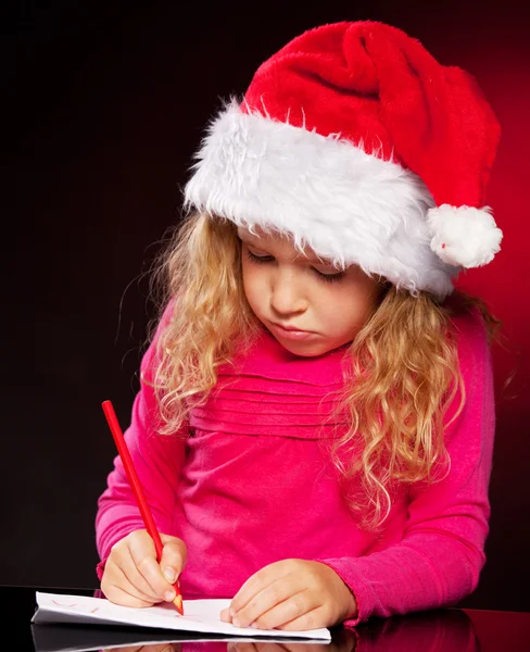Mädchen schreibt einen Brief an den Weihnachtsmann — Stockfoto
