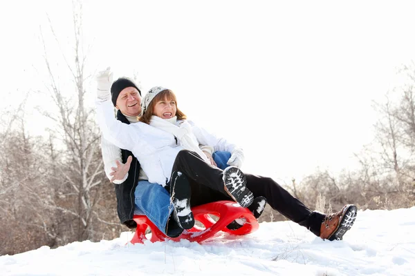 Mature couple sledding — Stock Photo, Image