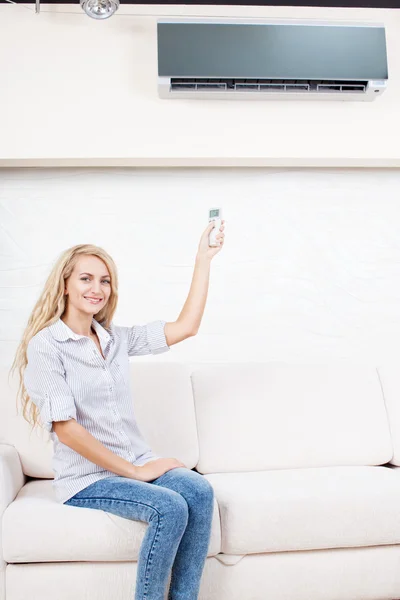 Female holding a remote control air conditioner — Stock Photo, Image