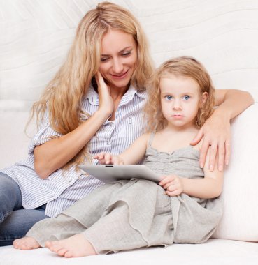 Anne ve kızı kanepe, tablet ile