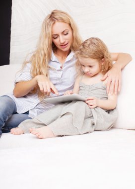 Anne ve kızı kanepe, tablet ile