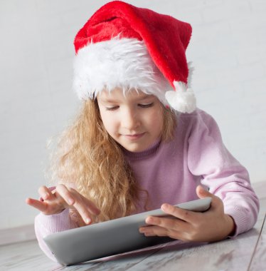 tablet ile Noel şapkalı çocuk
