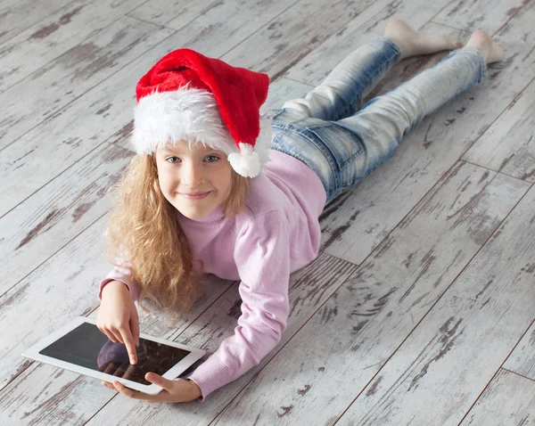 Tablet ile Noel şapkalı çocuk — Stok fotoğraf