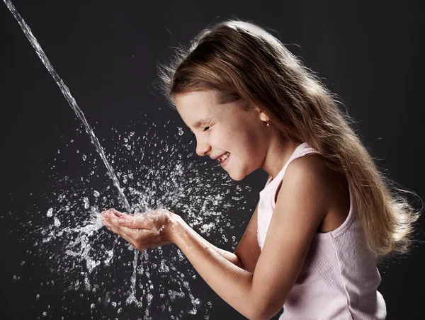 Stroom van schoon water gieten in de handen van kinderen — Stockfoto