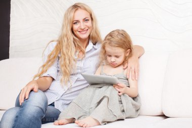 Anne ve kızı kanepe, tablet ile