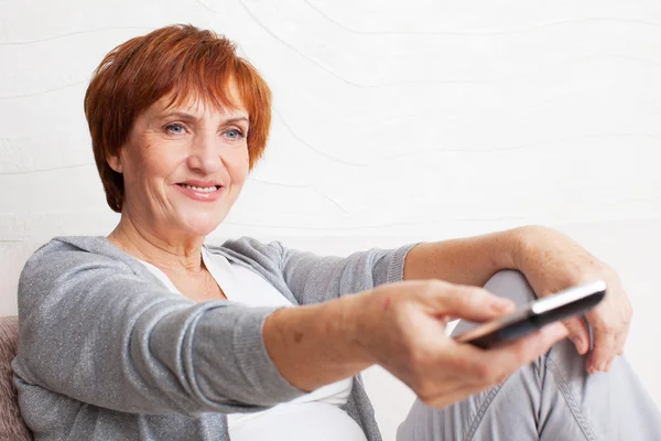 Adult woman with remote control — Stock Photo, Image