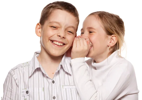 Девушка шепчет мальчику на ухо секрет — стоковое фото