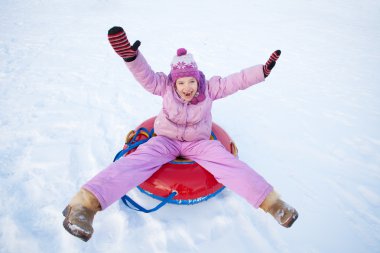Child sledding in winter hill clipart