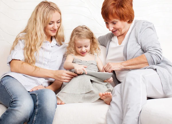 Rodziny z komputera typu tablet na kanapie — Zdjęcie stockowe