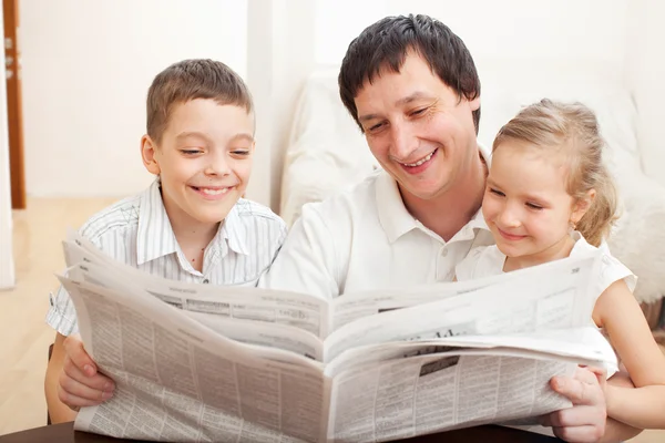 Familj läser en tidning — Stockfoto