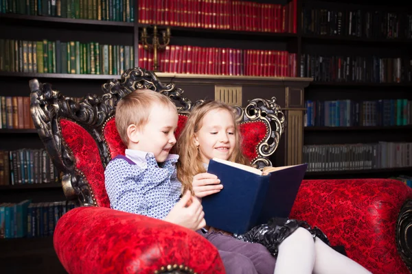 Niños leyendo libro en casa — Foto de Stock