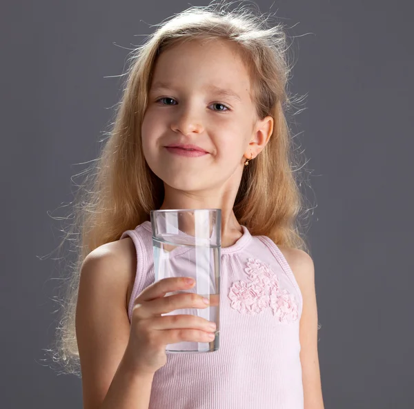 Flicka dricksvatten från glas — Stockfoto