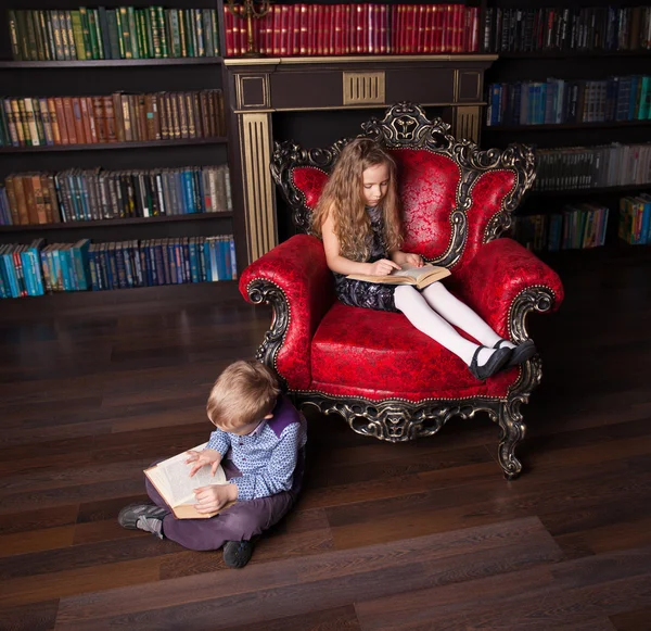 Crianças lendo livro em casa — Fotografia de Stock