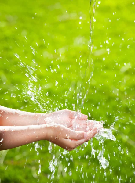 Corriente de agua limpia que vierte en las manos de los niños — Foto de Stock