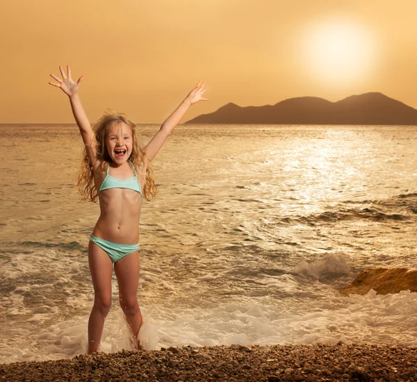 Flicka på stranden vid solnedgången — Stockfoto