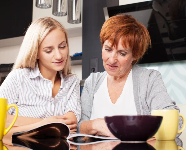 Mutter und Tochter lesen Zeitung zu Hause — Stockfoto