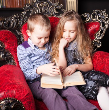 Çocuklar evde kitap okuyor.