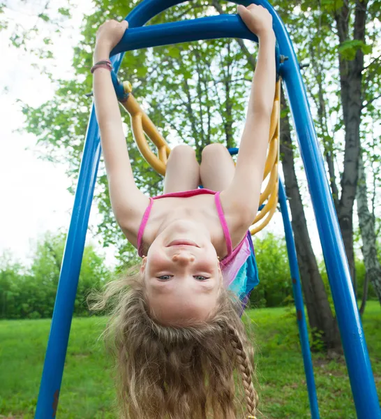 Girl hanging on horizontal bar — Stock Photo, Image