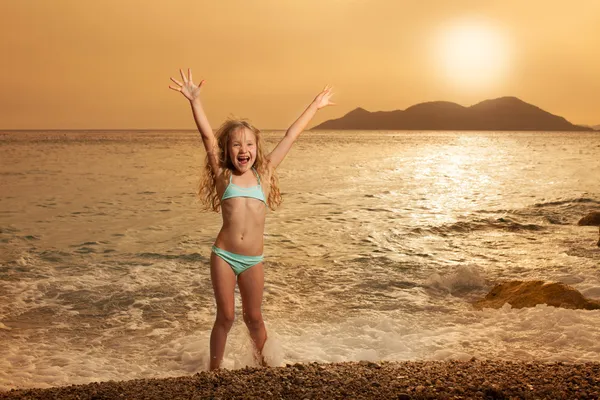 Menina na praia ao pôr do sol — Fotografia de Stock