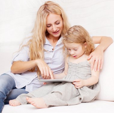 Anne ve kızı kanepe, tablet ile