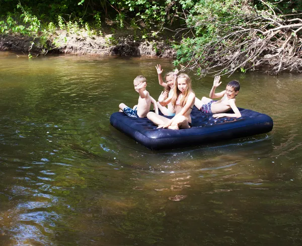 Children floating on the river — Stock Photo, Image