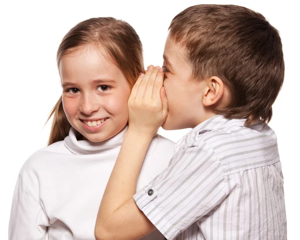 Мальчик шепчет девушке на ухо секрет — стоковое фото