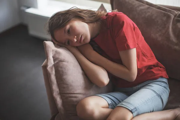 忧心忡忡的少女坐在沙发上感到沮丧 生气或孤独 心烦意乱的少女遭受虐待 骚扰或伤心 悲伤的少女或暴力受害者有心理问题 — 图库照片