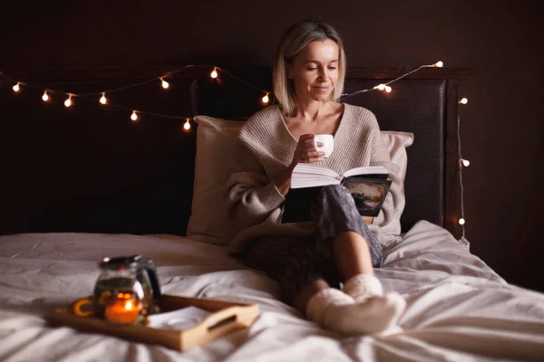 40多岁的成年女子在舒适的家中躺在床上看书 中年妇女在冬天或秋天的一天都会在卧室里休息 — 图库照片