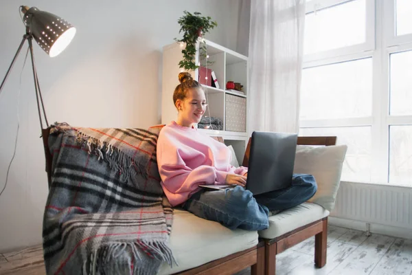 Gülümseyen Beyaz Kadın Oturma Odasında Kanepede Oturuyor Dizüstü Bilgisayarda Çalışıyor — Stok fotoğraf