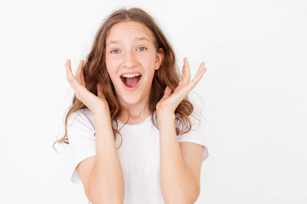 Cheerful happy young beautiful girl looking at camera smiling laughing over white background. Happy teen  in white t-shirt