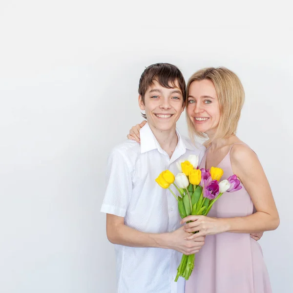 息子は 休日のためお母さんの花の花束を与えます 十代の存在の母チューリップ 母の日 ストック画像