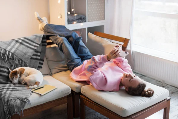 Flickan Som Ligger Soffan Och Håller Telefonen Händerna Rosa Tröja — Stockfoto