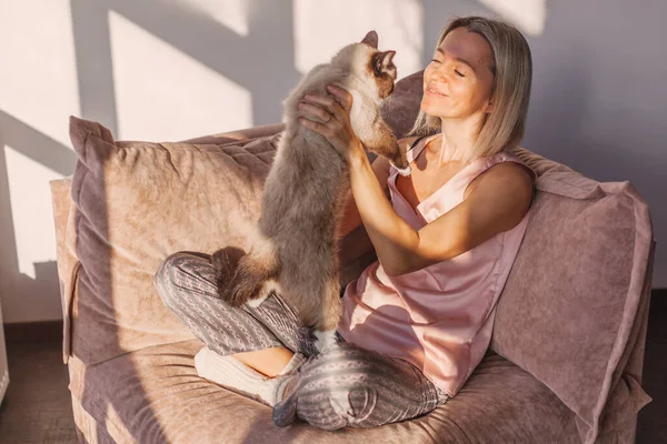 中年の女性は週末を家で過ごす 笑顔女性遊びますともに彼女の最愛の犬とともにザカウチに座って — ストック写真